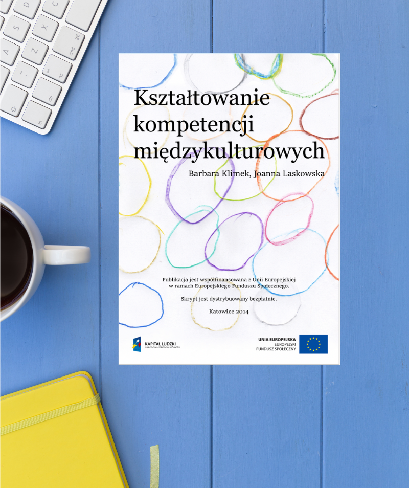 Grafika. W centrum książka: Kształtowanie kompetencji międzykulturowych - Barbara Klimek, Joanna Laskowska, 2024. Z lewej pokazana częściowo: klawiatura, kawa, notatnik.
